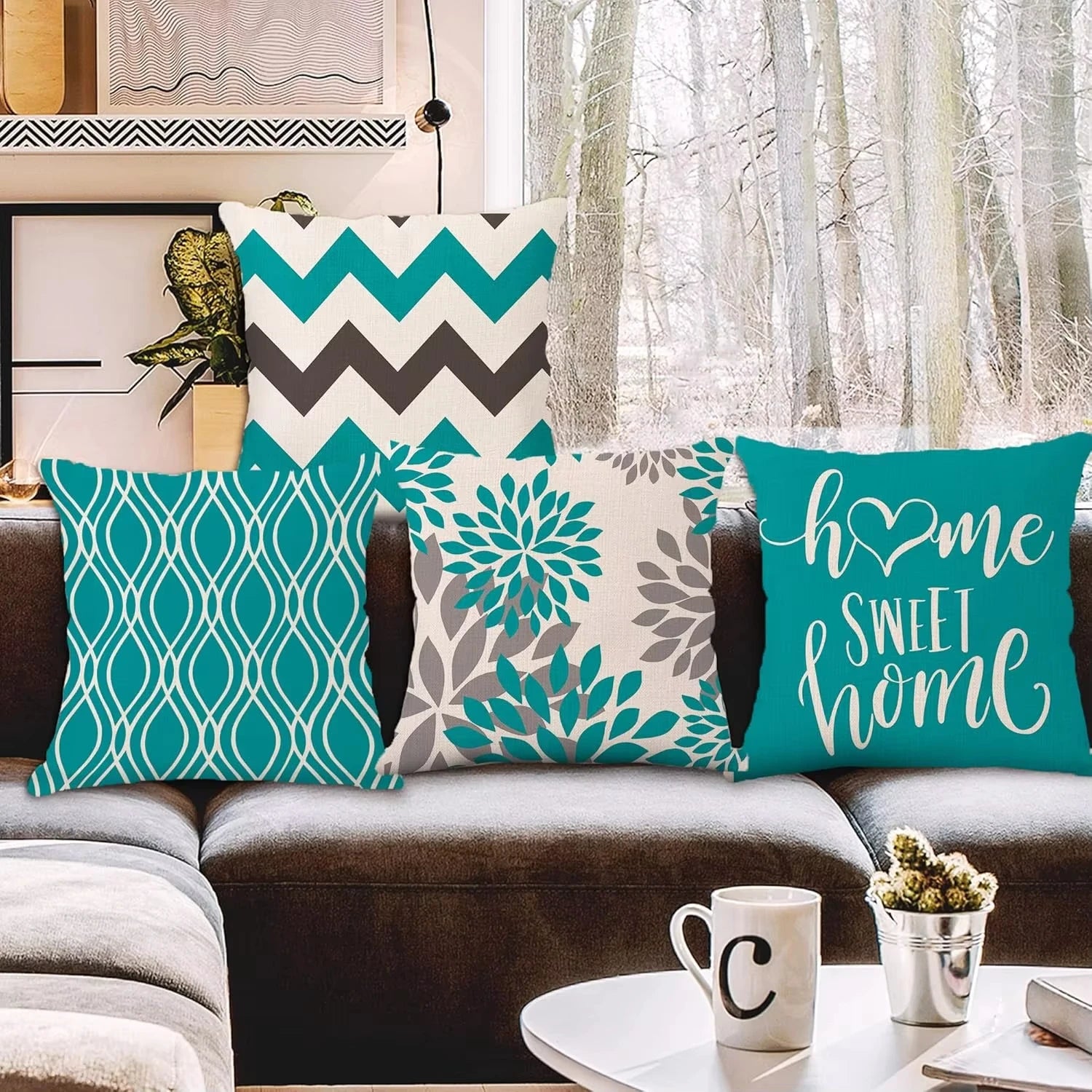 Decorative pillows on a couch with a winter scene outside