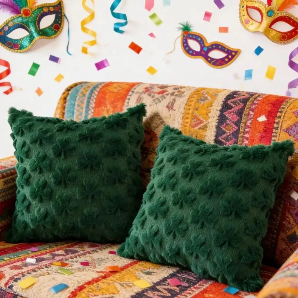 Two green textured pillows on a colorful couch with party decorations in the background.