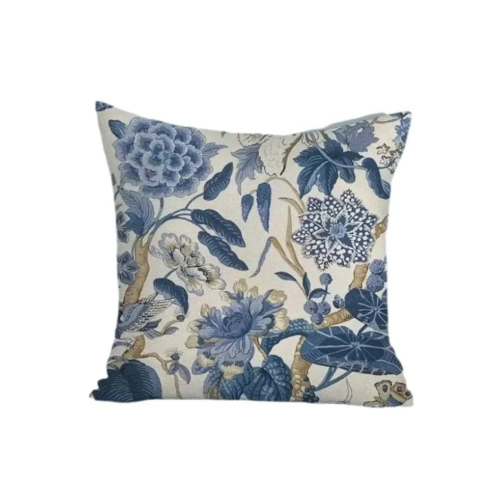 Decorative pillow with blue floral and bird pattern on a white background