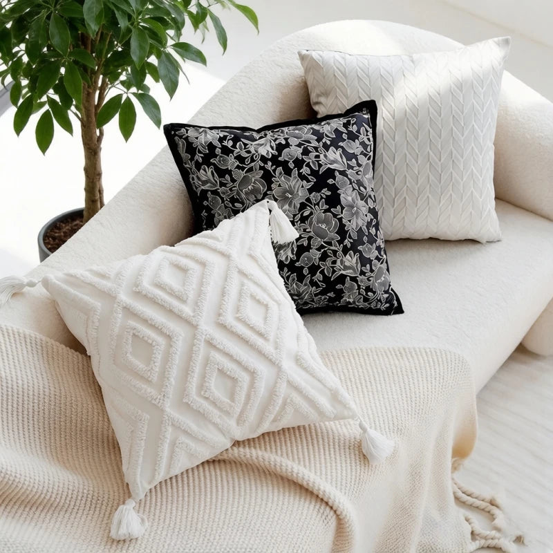 Decorative pillows on a sofa with a plant in the background