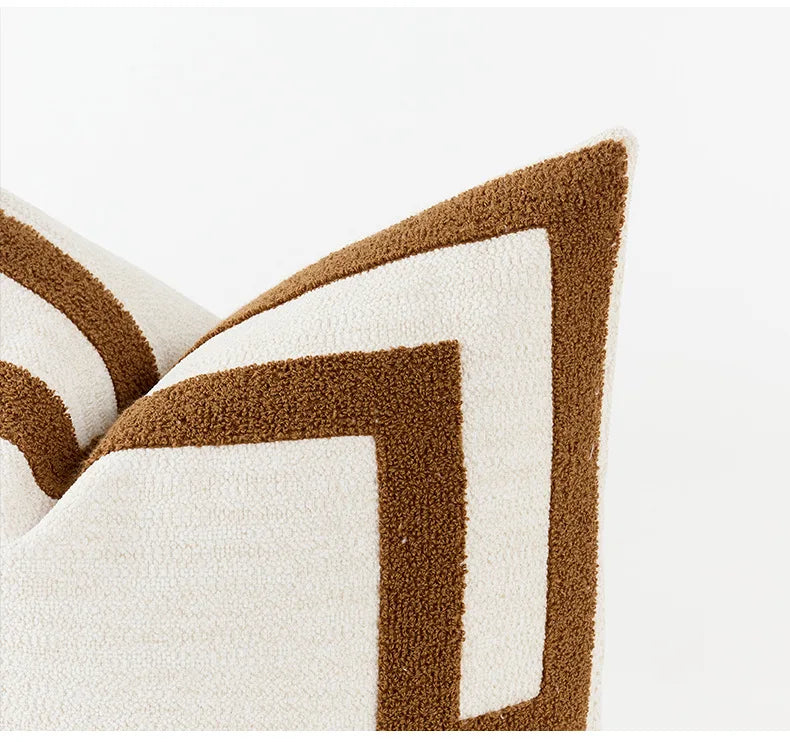 Close-up of a decorative pillow with brown and white chevron pattern on a white background