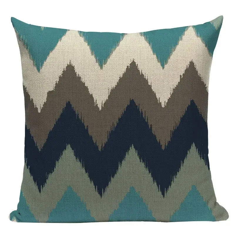 Decorative pillow with chevron pattern in teal, beige, brown, and navy on a white background