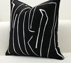 Black pillow with white abstract lines on a white background