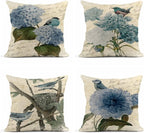 Set of four decorative pillows with floral and bird designs on a white background